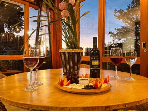 a table with wine glasses and a plate of food at Pousada Cantinho da Serra in Campos do Jordão