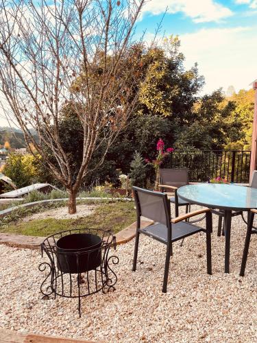 a patio with a table and chairs and a fire pit at Pousada Cantinho da Serra in Campos do Jordão
