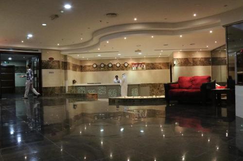 a lobby with a red couch and a red chair at Marina Tower in Juffair