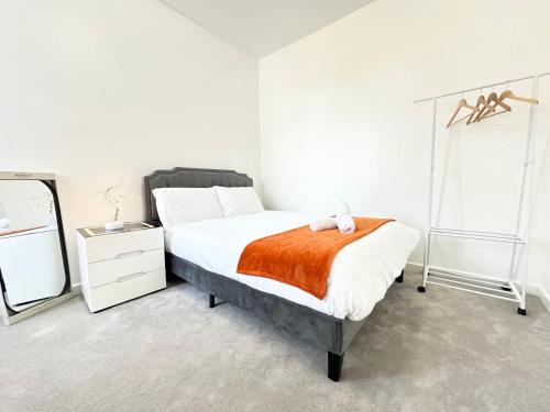 a bedroom with a bed with an orange blanket at 8-Sleeper 4BR 4Bed 2Bath Wi-Fi Garden Tv Beach in Portsmouth