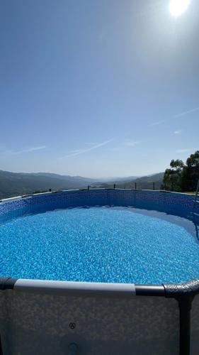 a large pool with blue water on a patio at Villa Garcia in Terras de Bouro