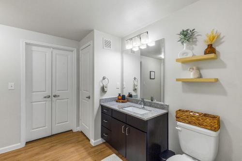 a bathroom with a sink and a toilet and a mirror at Long Stays Welcome, Pool, Free Parking, and Balcony in Austin
