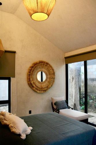 a bedroom with a bed and a mirror on the wall at CASA TAMA in La Ermita, Mérida Center with pool in Azcorra