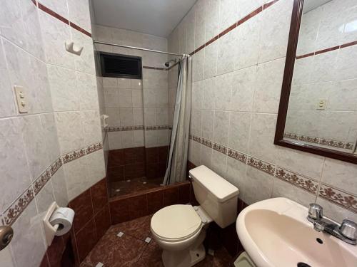 a bathroom with a toilet and a sink and a shower at Solis Dies Hotel in Lima