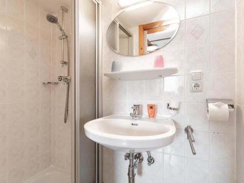 ein weißes Badezimmer mit Waschbecken und Spiegel in der Unterkunft Rettenstein und Gaisbergblick in Kirchberg in Tirol