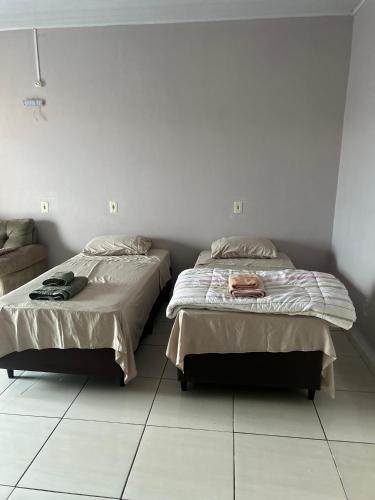 two beds sitting next to each other in a bedroom at Kitnet RS- Espaço Confortável in Canoinhas