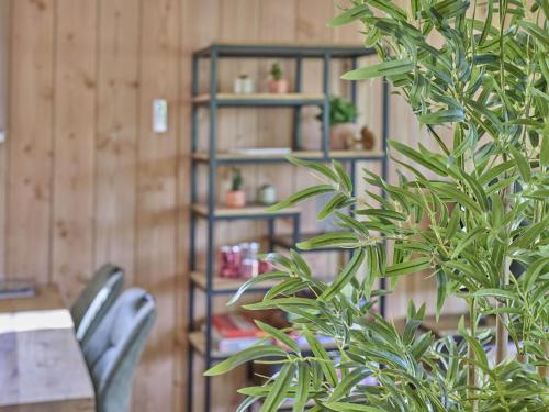 a table and two chairs and a book shelf with plants at Veldzicht in Bocholt