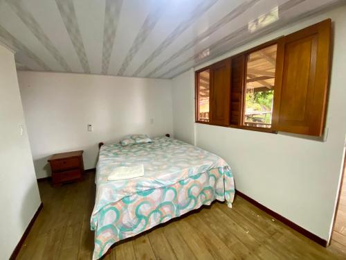 a bedroom with a bed and a window at Cabañas Las Perlas in Bahía Solano