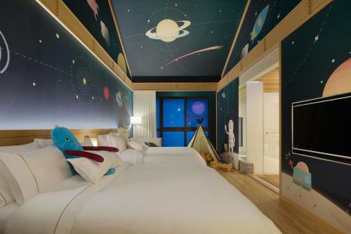 a bedroom with two beds and a wall with planets at The Westin Yilan Resort in Yuanshan