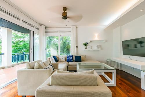 a living room with white furniture and a large window at Le Azul - 3BR Beachfront HOME in Laguna & Layan Beach next KORA Resort in Phuket