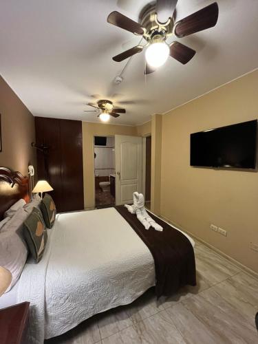 a bedroom with a large bed with a ceiling fan at Solis Dies Hotel in Lima