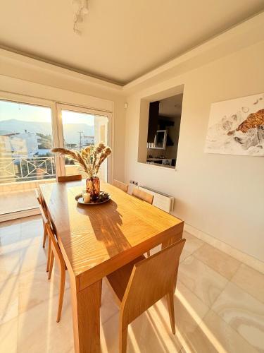 a dining room with a wooden table and chairs at Luxury SeaView Villa Pool-Bbq in Neos Voutzas