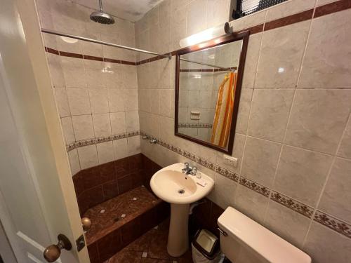 a bathroom with a sink and a toilet and a mirror at Solis Dies Hotel in Lima