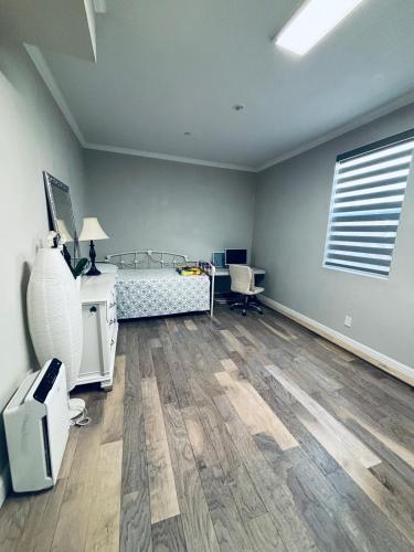 a bedroom with a bed and a desk and a window at 个独立房间在一个高尚安静的社区交通便利停车洗衣房露台 in Rancho Bernardo