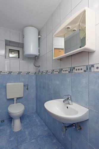 a bathroom with a toilet and a sink at Apartment Lopar 14804a in Lopar