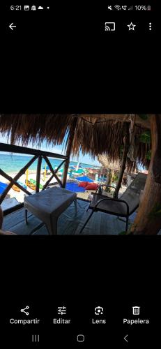 a view of a beach with a chair and a straw umbrella at Hostal Ananda in Playa Blanca