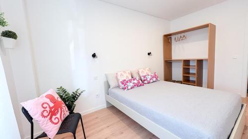 una piccola camera da letto con un letto e uno specchio di Vizinho -Central - perto praia - Wi-Fi a Setúbal