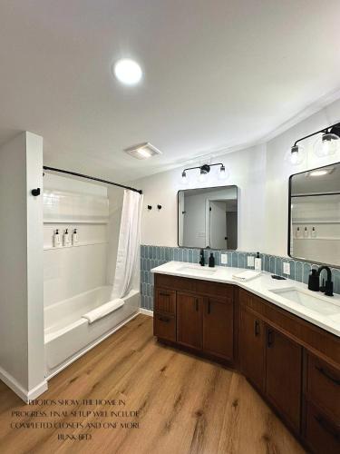 a bathroom with a tub and two sinks and a shower at Sun & Sand Resort in Port Austin