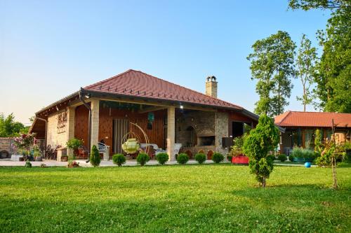 a house with a green lawn in front of it at Imanje NAŠA PRIČA 