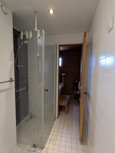 a bathroom with a shower with a glass door at Nice and spacious apartment in center - own carport and private sauna in Rauma