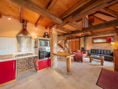 une cuisine avec des placards rouges et un salon dans l'établissement Gîte rural de charme avec sauna, forêt à proximité et prairie avec chevaux - FR-1-590-119, à Vitry-aux-Loges