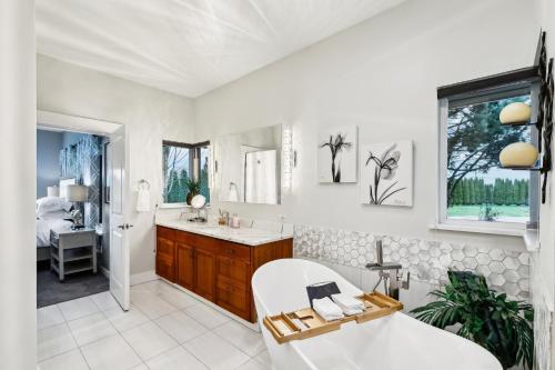 a white bathroom with a tub and a sink at New Skagit Tulip Farm Estate 3 beds 2 baths in Mount Vernon