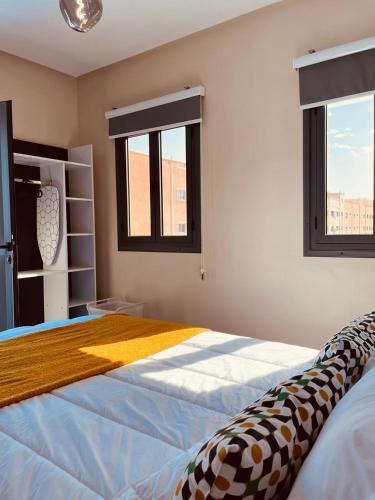 a bedroom with a large bed and two windows at Relax Family 06 - Cozy Studio in City Center in Ouarzazate