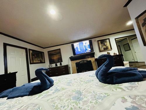 two blue towel swans laying on a bed at Cozy & Spacious 3BR Rustic Stay Minutes from LAX in Compton