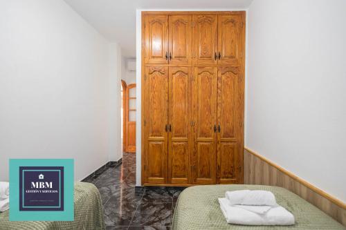 a bedroom with two beds and a wooden cabinet at Casa Lolita, Valsequillo in Islas Canarias