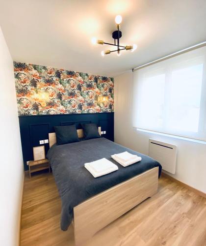 une chambre avec un grand lit et une fenêtre dans l'établissement L appart Quimperois Centre ville, à Quimper
