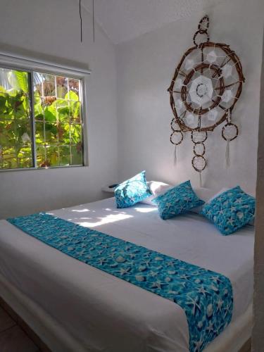 a bedroom with a large bed with blue pillows at Casa en Ixtapa 3 recamaras con alberca in Ixtapa