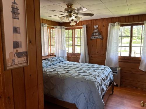 a bedroom with a bed and a ceiling fan at Sure Game Wilderness Resort in Wirt