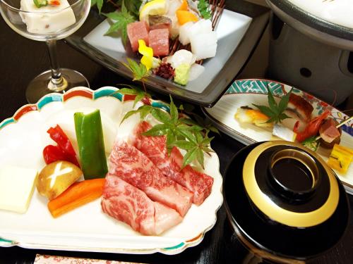 a plate of food with meat and vegetables on a table at Kirishima miyama hotel in Kirishima