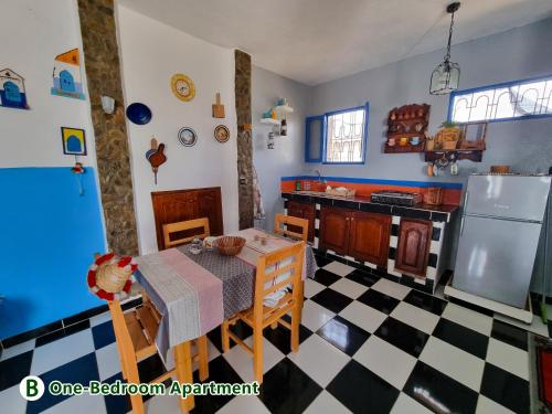 a kitchen with a table and a refrigerator at dar zaiouane in Berga