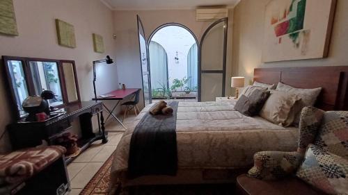 a bedroom with a bed and a desk and a mirror at Suite Conforto com ar e wi-fi, super bem localizado in Campinas