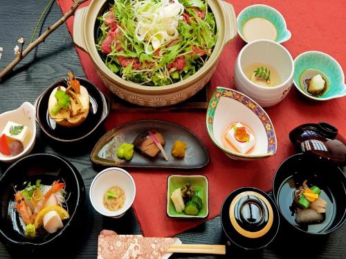 a table with plates of food and bowls of food at Kirishima miyama hotel in Kirishima