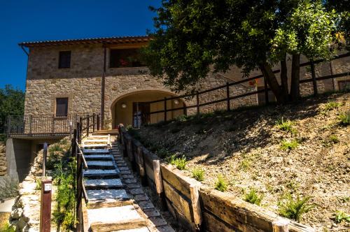 een stenen huis met een trap naar een gebouw bij Borgo Buciardella in Baschi