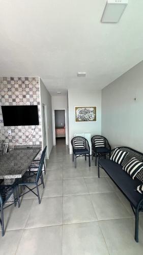 a living room with chairs and a couch and a tv at Casa do Airton in Icapuí