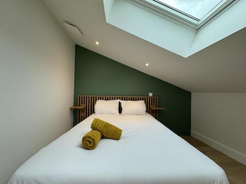 - une chambre avec un grand lit blanc et une lucarne dans l'établissement Apartment in Le Mans with Terrace Views, au Mans