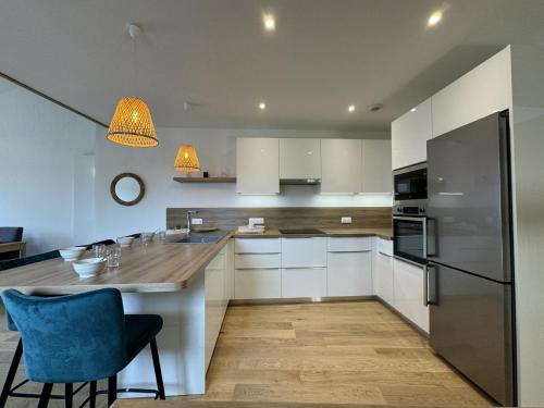 une cuisine avec des placards blancs et une chaise bleue dans l'établissement Apartment in Le Mans with Terrace Views, au Mans