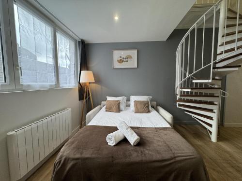une chambre avec un lit et un escalier en colimaçon dans l'établissement Duplex in Le Mans near 24 Hours Circuit, au Mans