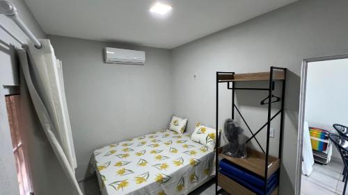 a small bedroom with a bed and a shelf at Casa do Airton in Icapuí