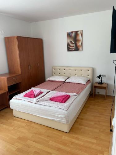 a bedroom with a bed with pink towels on it at Vila Dunjić Prolom Banja in Prolomska Banja