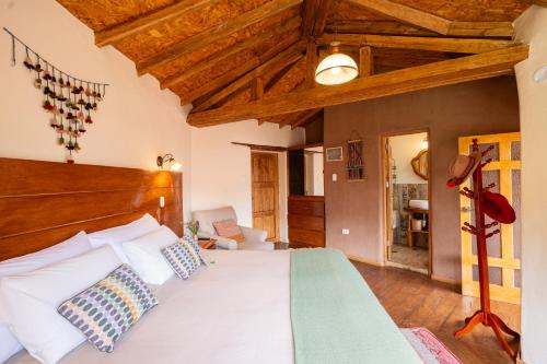 a bedroom with a large bed with a wooden ceiling at Unuwasi Hotel & Villa in Calca