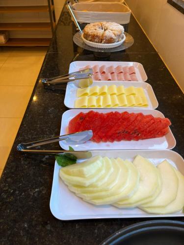 four plates with different types of food on a counter at My House Muriqui in Mangaratiba