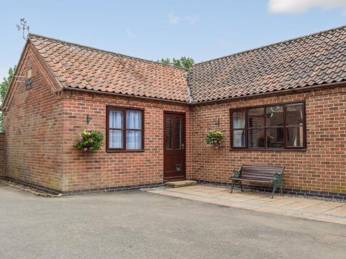 a brick building with a bench in front of it at Glossoms Lodge in Scalford