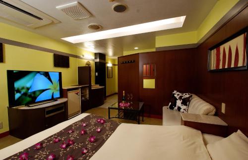 a hotel room with a bed and a flat screen tv at Comfort Hotel Hu in Koshigaya