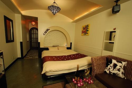 a bedroom with a large bed and a couch at Comfort Hotel Hu in Koshigaya