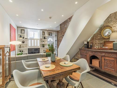 a dining room with a table and chairs and a fireplace at St Margarets Cottage in King's Lynn