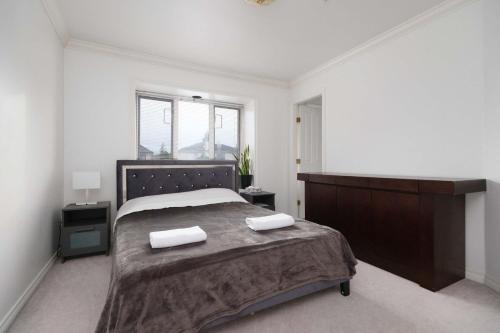 a bedroom with a large bed with two towels on it at Spacious Room with Private Washroom in Homestay in Vancouver
